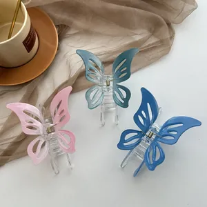 Three gradient butterfly hair claws in pink, teal, and navy blue with metal springs