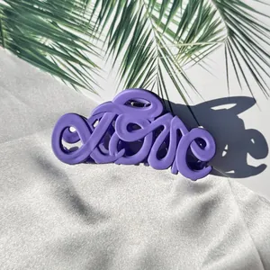 Detail der mattvioletten großen Haarklammer mit einzigartigem Love-Schriftzug-Design