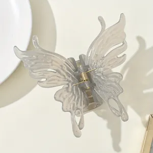 Detail of a translucent grey butterfly hair claw clip with a strong gold metal spring