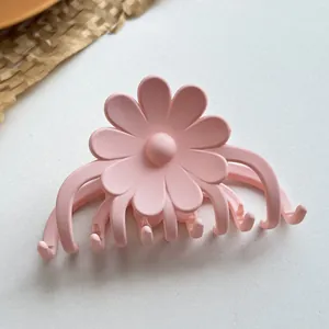 Detail einer rosa matten Gänseblümchen-Haarklammer mit großem Blumenharz-Design
