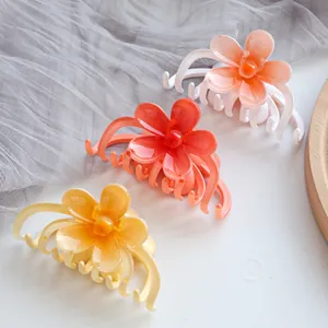 Cute candy-colored matte plumeria flower hair claws in pink, orange, and yellow shades