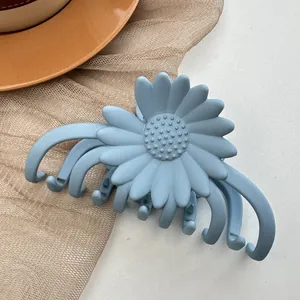 Close-up of matte light blue daisy hair claw clip with detailed petal design