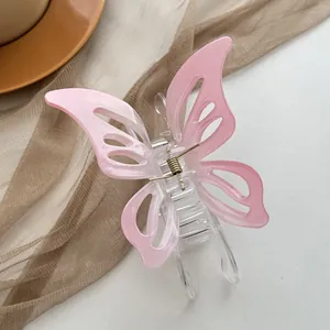 Macro detail of hollow pink butterfly hair claw with transparent body and gold spring