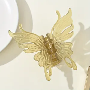 Detailed close-up of a yellow translucent butterfly hair claw with a gold metal spring