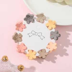Detailed macro of colorful matte floral hair mini claws arranged on a display card