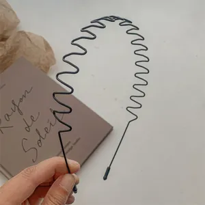 Détail du serre-tête en métal noir ondulé avec embouts protecteurs pour un confort optimal