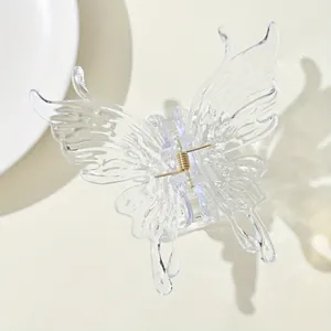 Macro view of translucent butterfly hair claw clip with gold metal spring detail