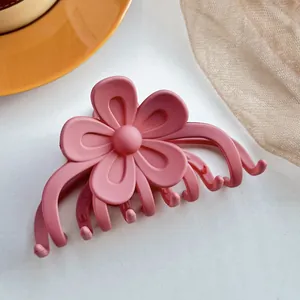 Vue détaillée d'une pince à cheveux fleur rose mate avec une finition givrée raffinée