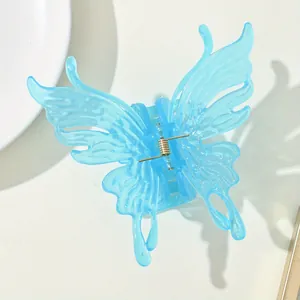 Detail of light blue translucent butterfly hair claw with a strong gold metal spring