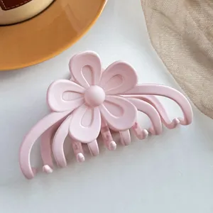 Gros plan d'une pince à cheveux fleur rose mate avec design robuste pour cheveux épais