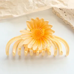 Detail einer gelben Gänseblümchen-Haarklammer mit floralen Blüten und Harzstruktur