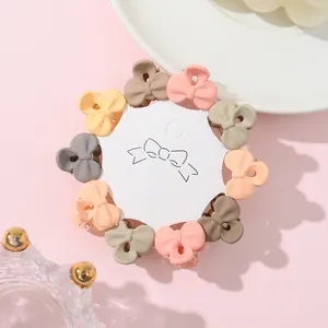Detailed view of 10-piece mini bow hair claws set in matte candy colors on display card