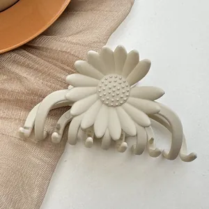 Detail of cream daisy hair claw clip with matte finish and secure grip teeth
