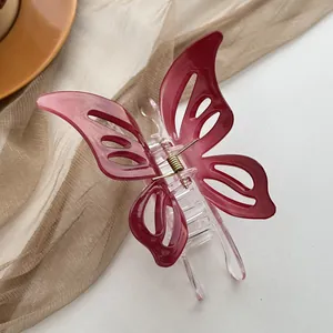Macro detail of wine red hollow butterfly hair claw clip with transparent base