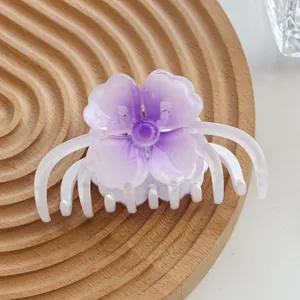 Macro detail of purple gradient flower hair claw clip with multi-tooth structure