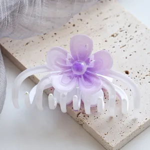Detailansicht der großen violetten Blumen-Haarklammer mit Farbverlauf auf Steinfläche