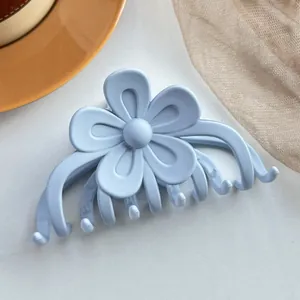 Détail d'une pince à cheveux fleur bleu clair mat avec une finition givrée lisse pour femmes
