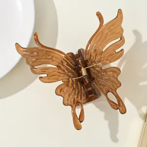 Macro detail of amber brown butterfly hair claw clip with golden metal spring