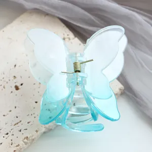 Dettaglio macro di un fermaglio per capelli a farfalla blu sfumato con molla dorata