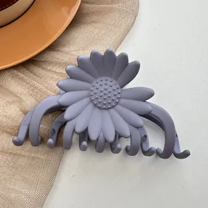Macro detail of daisy matte hair claw clip in Morandi grey-purple on ceramic plate