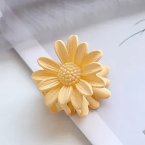 Makroaufnahme der 4,5 cm kleinen Gänseblümchen-Haarklammer aus mattem gelbem Kunstharz