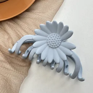 Close-up of matte grey-blue daisy claw clip with durable multi-teeth interlocking design