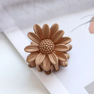 Nahaufnahme der 4,5 cm Gänseblümchen-Haarklammer in Mattbraun mit Schichtblüten-Design