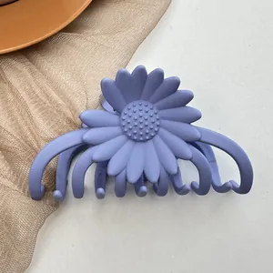 Detail of a matte lavender daisy hair claw clip with a realistic 3D floral petal design