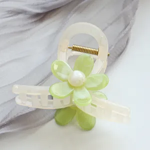 Detalle de pinza para el pelo de resina crema con flor verde y una perla