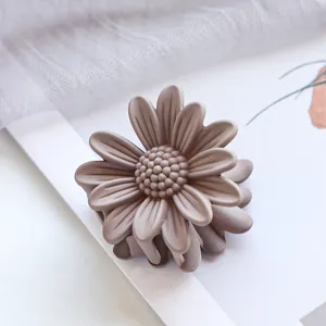 Makro-Detail der staubrosa Gänseblümchen-Haarklammer mit mattem Harz-Finish und Blütenblättern