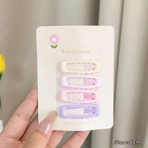 Detailed view of four 4cm wave-shaped colorful hair clips in pastel cream and pink