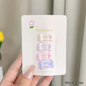 Set of four 2.5cm bone-shaped hair clips in macaron colors on a display card