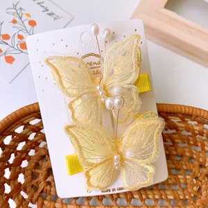 Detail von gelben Netz-Schmetterlings-Haarspangen mit Goldstickerei und weißen Perlen