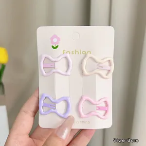 Four 3cm macaron-colored bow hair clips displayed on a floral fashion card