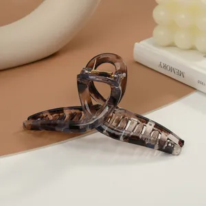 Detailansicht der Haarspange mit Leopardenmuster, goldener Feder und Schildpatt-Textur
