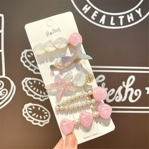 Detail view of 5-piece ocean theme hair clips with faux pearls and glittery seashells