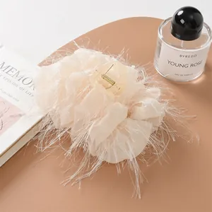 Elegante pinza per capelli in piume beige con lunghe nappe su uno sfondo di design
