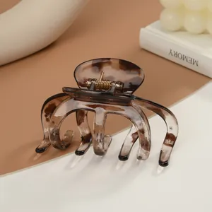 Detailaufnahme der großen Haarspange mit Schildpattmuster und goldener Metallfeder