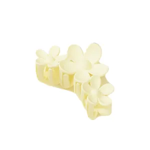 Detalle de la pinza para el cabello de flores crema mate con pétalos de textura suave