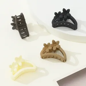 Set of four matte flower hair claws in black, cream, light brown, and dark coffee tones