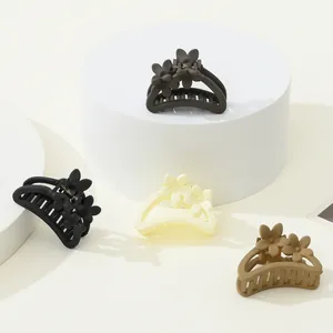 Matte flower hair clips set in black grey cream and brown on white pedestals