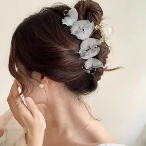 Detailed side view of large butterfly hair claw clip with pearls on elegant updo hair
