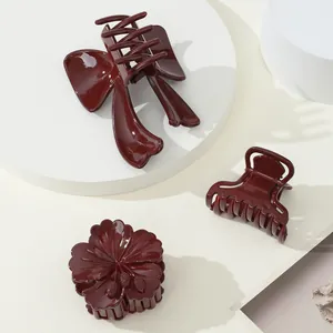 Set di mollette per capelli bordeaux con fiocco e fiori su supporto bianco minimalista