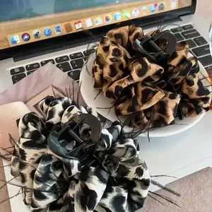 Large leopard print hair claw clips with feather trim decorations in two colors
