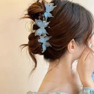 Detail of light blue mesh butterfly hair claw clip worn by a model in a romantic updo