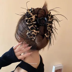 Leopard print hair claw clip with black feathers worn in a stylish updo hairstyle