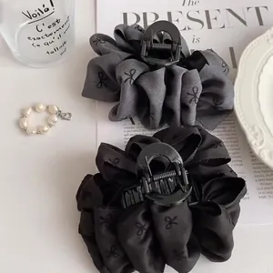 Elegant large black bubble bow hair claw clips for women shown with French-style decor