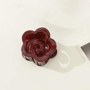 Close-up of a mini dark red flower hair claw clip with a glossy finish and spring design