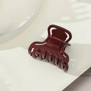 Dettaglio dell'elegante pinza per capelli a farfalla bordeaux con finitura lucida