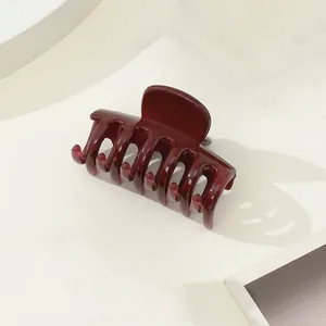 Macro detail of the deep burgundy hair claw clip with a glossy finish and strong spring